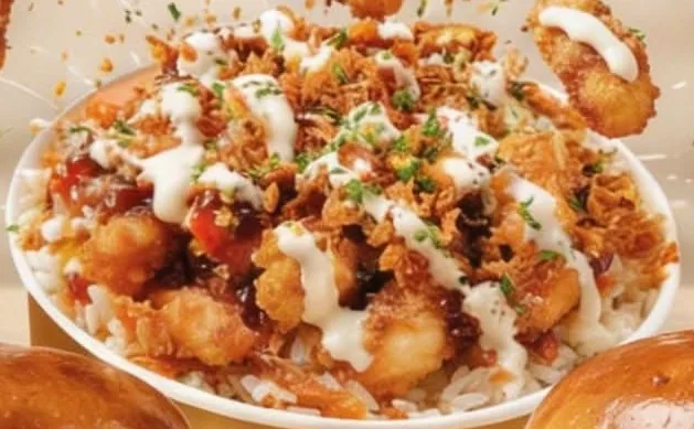 Bol de riz blanc recouvert de poulet croustillant, sauce fromagère et oignons frits
